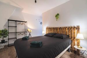 Un dormitorio con una cama grande con una bolsa verde. en Logis du Lys en Boult-sur-Suippe