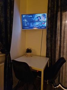 a table with two chairs and a tv on the wall at Appartment Del Pueblo/Netflix/Zentral/Ideal für 4! in Weiden