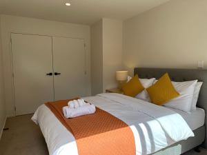 Un dormitorio con una cama con una toalla. en Northshore Charming 4 bedrooms, en Auckland