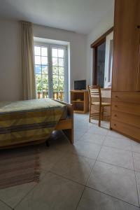 Belandin Ristorante Hotel في تيجليو: غرفة نوم بسرير وطاولة وكراسي