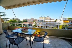 a patio with a table and chairs on a balcony at Beautiful apartment in Glyfada center in Athens