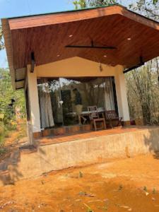 a house with a porch with a table in it at Vanoshi Forest Homestay,Kudase in Maneri