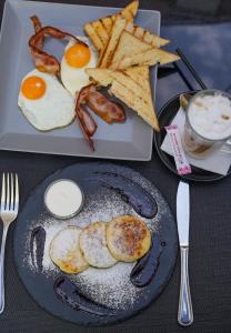 um prato de pequeno-almoço com ovos, bacon e torradas em Vintage Art Hotel em Odessa