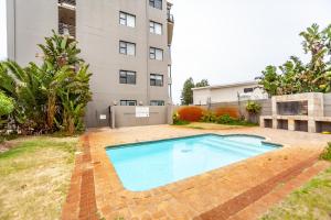 una piscina nel cortile di un edificio di Beachfront 3rd floor 2 bedroom w communal swimming pool- B16 Blouberg a Bloubergstrand
