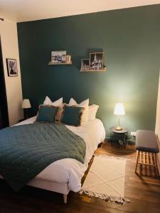 a bedroom with a large bed with a green wall at Suite Garden by La Boîte En Plus in Senlis