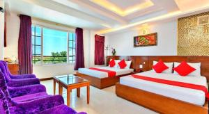 a hotel room with two beds and a couch at Khách Sạn Cường Thanh 1 in Ho Chi Minh City