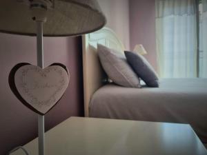 un signo cardiaco en una lámpara junto a una cama en La Maison, en Albelda de Iregua