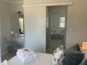 a bathroom with a sink and a couch with towels at Bond Self-Catering Unit in Knysna +25 photos