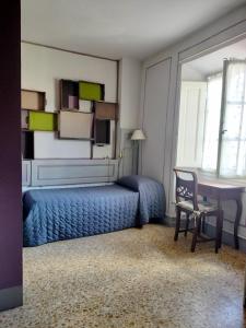 a bedroom with a bed and a desk and a table at Foresteria San Niccolo' 14 in Prato