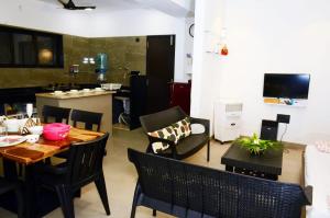 a dining room and kitchen with a table and chairs at alibaug serenity villa in Alibaug
