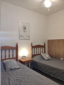 1 dormitorio con 2 camas y una lámpara en una mesa en Аппартаметы Seguro De Sol Playa de la Arena, en Puerto de Santiago