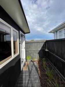 a black house with a window and a fence at Minimalist Cabin Solo Traveller in Ashburton