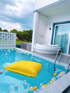 Good View Pool Villa Udonthani في أودون ثاني: مسبح فيه حوض وعوامة صفراء