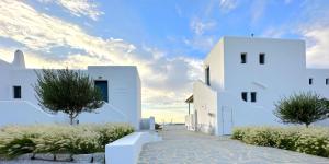a row of white buildings with trees and bushes at Archon Seaside Retreat in Plaka