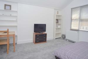 a bedroom with a bed and a desk and a television at SOHO Flat (Central London) in London