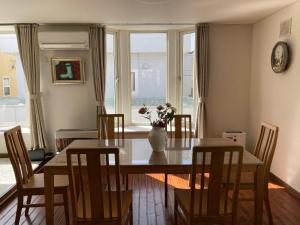 a dining room with a table and a vase with flowers at Snow House Hotel in Sapporo