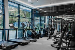 a gym with treadmills and machines in a building at Bursztynowe Resort&SPA Stegna in Stegna