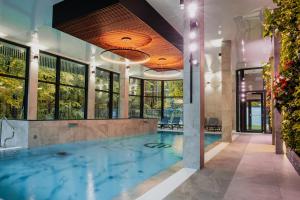 a swimming pool in a building with windows at Bursztynowe Resort&SPA Stegna in Stegna