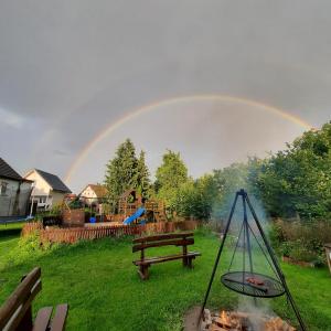 a rainbow over a park with a picnic table and a fire at Na Spokojnej Rodzinne Wakacje in Pogorzelica