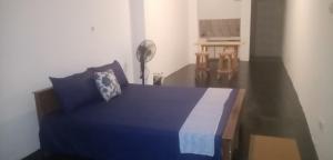 a bedroom with a blue bed and a table at Full Large room in Colombo