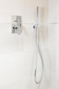 - prysznic w wyłożonej białymi kafelkami łazience w obiekcie Maison Aubert in Centro Storico w Aoście