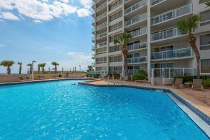 einem Pool vor einem Gebäude mit Palmen in der Unterkunft Beachside II 4288 in Destin