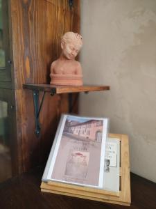 posąg siedzący na półce obok książki w obiekcie Foresteria San Niccolo' 14 w mieście Prato