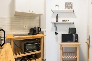 a kitchen with white cabinets and a microwave oven at Zeus Temple view 2BD Apartment by UPSTREET in Athens