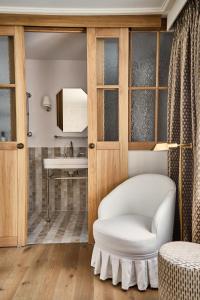 sala de estar con silla blanca y espejo en Magda Boutique Rooms, en Londres