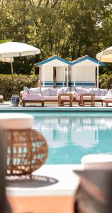 een zwembad met ligstoelen en parasols bij California Park Hotel in Forte dei Marmi