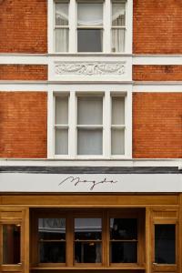 una fachada de un edificio de ladrillo con un cartel en él en Magda Boutique Rooms, en Londres