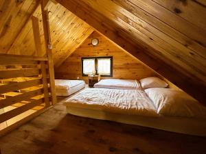 een slaapkamer met 2 bedden op een houten zolder bij Pod Chmielarzem in Wojcieszów