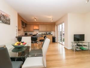 a kitchen and living room with a glass table at Fell Haven in St Bees
