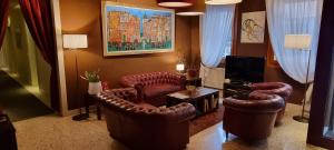 ein Wohnzimmer mit Ledersesseln und einem TV in der Unterkunft UNAWAY Ecohotel Villa Costanza Venezia in Mestre