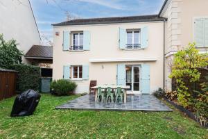 a table and chairs in the yard of a house at Jolie Maison Disneyland Bmyguest in Magny-le-Hongre