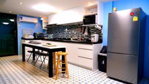 a kitchen with a table and a refrigerator at BEB Silom Condolette in Bangkok