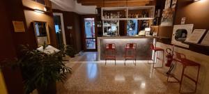 un bar con due sgabelli rossi in una stanza di UNAWAY Ecohotel Villa Costanza Venezia a Mestre