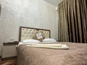 a bedroom with a large bed with a large headboard at RATMINA HOTEL in Nukus