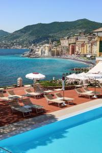 a view of a resort with chairs and a pool at Hotel Cenobio Dei Dogi in Camogli