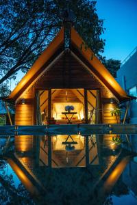 a house with a large window and lights on it at Treellion Jungloo in Phnom Penh