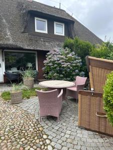 a patio with a table and chairs in front of a house at Hideaway in Kampen
