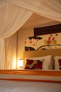 a bedroom with a bed with a canopy and pillows at Treellion Jungloo in Phnom Penh