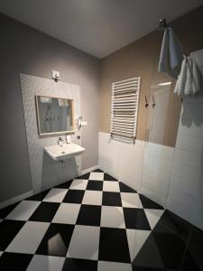 een badkamer met een zwart-wit geruite vloer bij Pałac Konary 