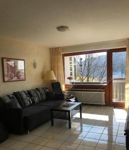 a living room with a black couch and a table at Appartment 1021, Missen-Wilhams in Missen-Wilhams