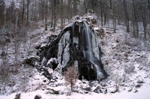 a waterfall is covered in snow in a forest at TraumFeWo Morgentau in Bad Harzburg