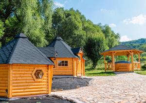 une cabane en rondins et un kiosque dans la cour dans l'établissement Pod Chmielarzem, à Wojcieszów