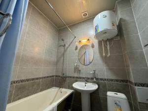 ein Badezimmer mit einem Waschbecken, einem WC und einer Badewanne in der Unterkunft RATMINA HOTEL in Nukus