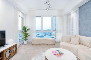 a living room with a couch and a tv at SEA and ATLANTIS VIEW COZY 3BR RESORT PALM JUMEIRAH in Dubai