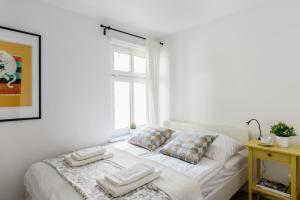 ein weißes Bett mit zwei Kissen und einem Fenster in der Unterkunft VIU Helska in Sopot