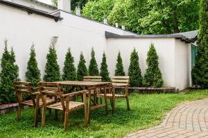 einen Holztisch und Stühle in einem Garten mit Bäumen in der Unterkunft VIU Helska in Sopot